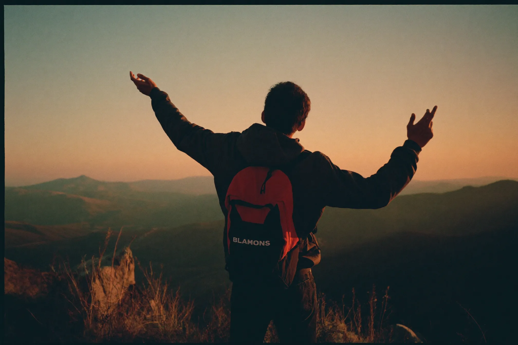 Founder celebrando un logro en la cima al amanecer